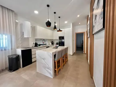 a kitchen with white cabinets and a large island at Crystal-Blue-Villa Protaras in Protaras