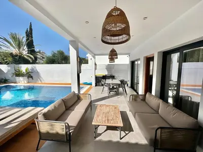 a living room with a couch and a table and a pool at Crystal-Blue-Villa Protaras in Protaras