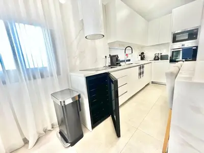 a white kitchen with a sink and a trash can at Crystal-Blue-Villa Protaras in Protaras