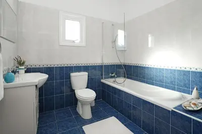 a blue tiled bathroom with a toilet and a sink at Villa Posidonia - 200m from Sandy Beach in Ayia Napa