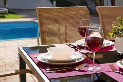 a table with two glasses of red wine on it at Villa Posidonia - 200m from Sandy Beach in Ayia Napa