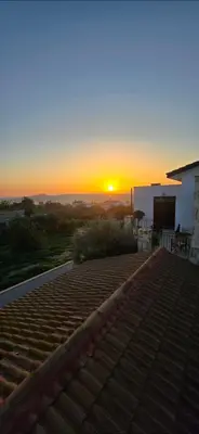 a sunset from the roof of a house with the sun setting at Olive Garden's Paradise Villa in Skarinou
