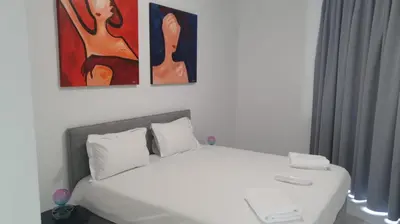 a bedroom with a bed with three paintings on the wall at Hypnos Residence in Nicosia