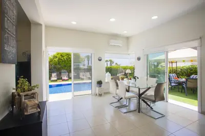 a living room with a table and chairs and a pool at Villa Elias in Ayia Napa