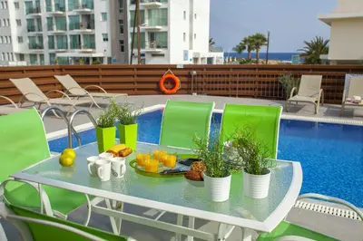 a table with a tray of fruit and plants on a balcony at Theodora in Protaras