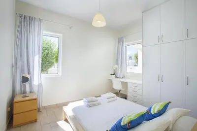 a white bedroom with a bed and a window at Protaras Seafront Villa Melissa in Protaras