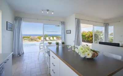 a kitchen with a counter with a view of the ocean at Protaras Seafront Villa Melissa in Protaras