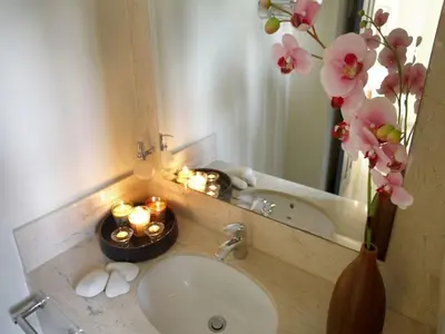 a bathroom sink with candles and a vase with flowers at Protaras Nausicaa Villa Mykonos in Protaras