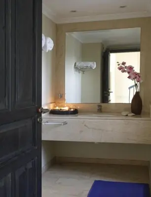 a bathroom with a sink with a mirror and a vase of flowers at Protaras Nausicaa Villa Mykonos in Protaras