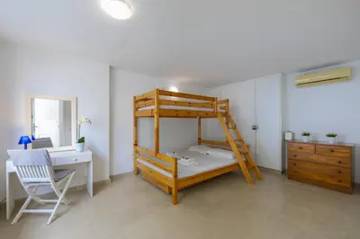 a bedroom with a bunk bed and a desk and a desk at Protaras Nausicaa Villa Mykonos in Protaras