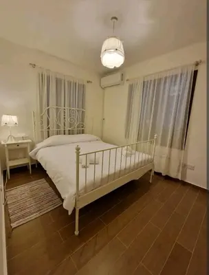 a bedroom with a white bed and a chandelier at Butterfly Home in Platres