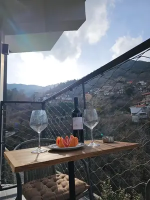a table with two wine glasses and a plate of fruit at THE CLIFF ALONA in Alona