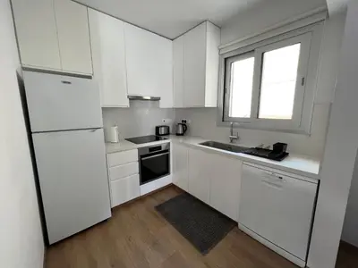 a white kitchen with white cabinets and a window at Prince Boutique Apartment/1BR in Nicosia
