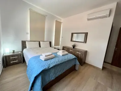 a bedroom with a bed with two towels on it at Kings Boutique Apartment/2BR in Strovolos