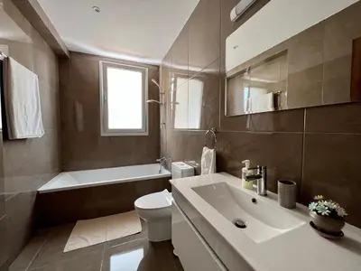 a bathroom with a sink and a tub and a toilet at Kings Boutique Apartment/2BR in Strovolos