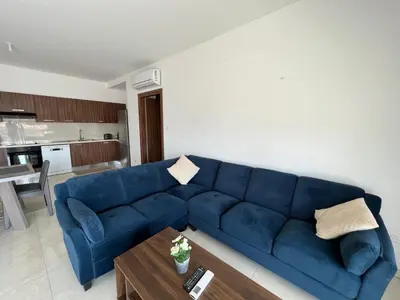 a blue couch in a living room with a table at Kings Boutique Apartment/2BR in Strovolos