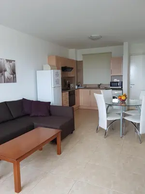 a living room with a couch and a table and a kitchen at Holiday Apartment with Sea View (0002913) in Paralimni