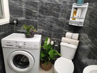 a bathroom with a washing machine and a toilet at Luxury Kalipso Beachfront in Limassol