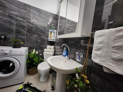 a bathroom with a sink and a toilet and a washing machine at Luxury Kalipso Beachfront in Limassol