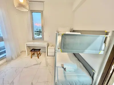 a small room with a bunk bed and a window at Sol e Mar Villa 2 in Paralimni