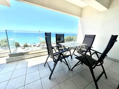 a table and chairs on a balcony with a view of the ocean at Eden Dream Apartments in Limassol