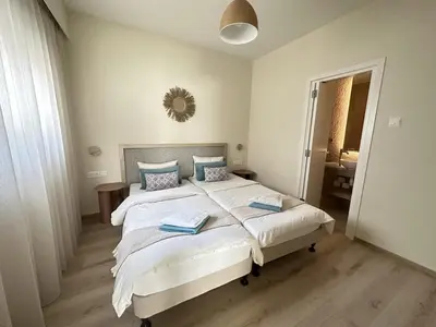 a bedroom with two beds and a mirror on the wall at Eden Dream Apartments in Limassol