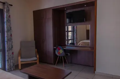 a room with a mirror and a table and a chair at Lakis Court in Larnaka