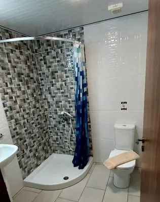a bathroom with a shower with a toilet and a sink at Lakis Court in Larnaka