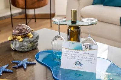 a table with two wine glasses and a bottle on it at Accomoteleia Crystal Lagoon Villa in Protaras