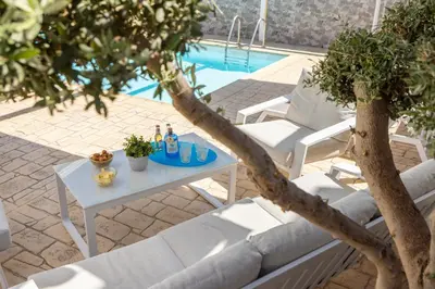 a table and chairs next to a swimming pool at Accomoteleia Crystal Lagoon Villa in Protaras