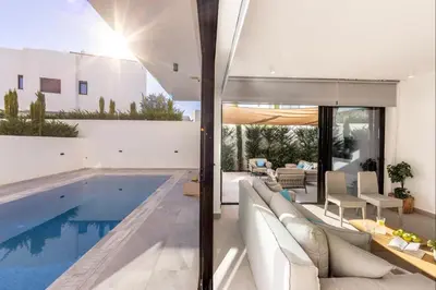 a house with a swimming pool and a living room at Protaras Periyiali Seaside Villa 33 in Protaras