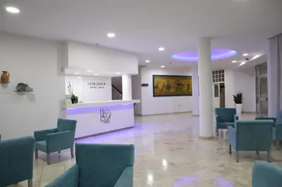 a lobby with a waiting room with blue chairs at Boronia Hotel Apartments in Larnaka
