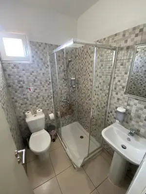 a bathroom with a toilet and a shower and a sink at Boronia Hotel Apartments in Larnaka