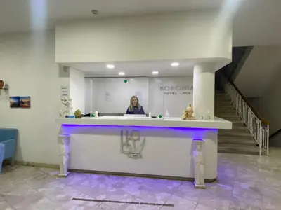 a woman standing behind a counter in a room at Boronia Hotel Apartments in Larnaka