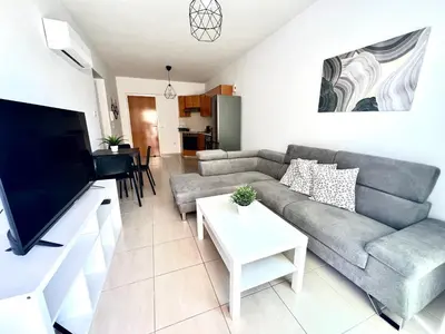 a living room with a couch and a tv at Mackenzie 11 in Larnaka
