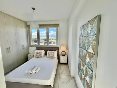 a bedroom with a bed with white sheets and a window at Alasia Villa ll Kapparis in Paralimni