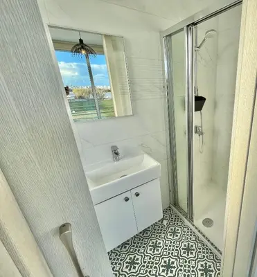a white bathroom with a sink and a shower at Alasia Villa ll Kapparis in Paralimni