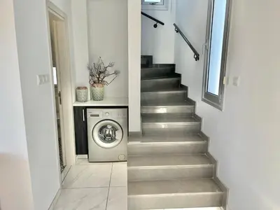 a staircase with a washer and dryer in a house at Alasia Villa ll Kapparis in Paralimni