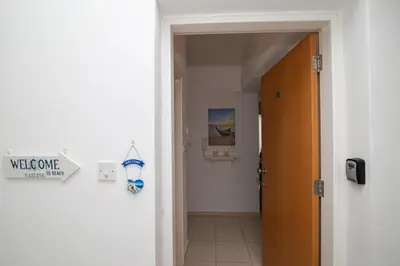 a hallway with awelcome sign on a wall next to a door at The Good Times Apartment in Protaras