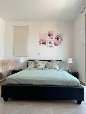 a bedroom with a large bed with three paintings on the wall at Villa TaMalDi side sea view - new renovated! in Paralimni