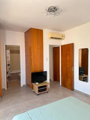 a living room with a television and a bed at Villa TaMalDi side sea view - new renovated! in Paralimni