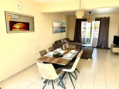 a living room with a table and a couch at Nissi 3 E8 Pool View Apt in Ayia Napa