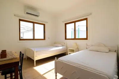 a bedroom with two beds and a desk and two windows at Captivating 2-Bed House in Alaminos