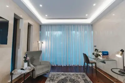 a living room with blue curtains and a chair at 16 EXECUTIVE SUITES in Nicosia
