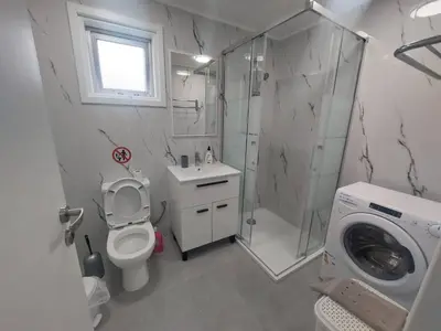 a bathroom with a shower toilet and a washing machine at AMAZING TWO BEDROOM APARTMENT in Ayia Napa