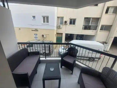 a balcony with a couch and chairs and a table at AMAZING TWO BEDROOM APARTMENT in Ayia Napa
