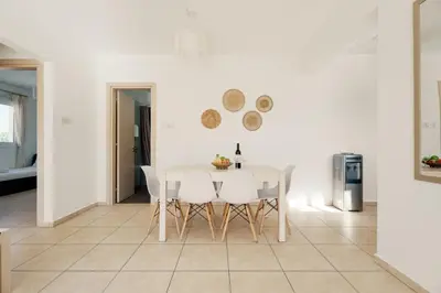 a white dining room with a white table and chairs at Cozy 2 Bedroom Family Apartment w/ Pool in Protaras