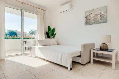 a white bedroom with a bed and a window at Cozy 2 Bedroom Family Apartment w/ Pool in Protaras