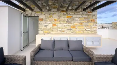 a living room with a couch and a stone wall at City Napa Seaview Villas - Villa 4 in Ayia Napa