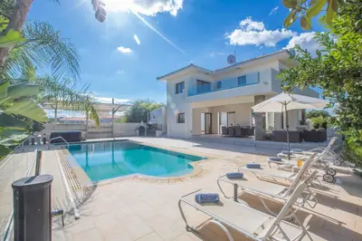 a swimming pool in front of a house at Protaras Demetra Villa DE1 in Protaras